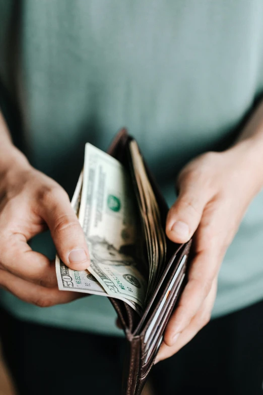 a person holding a wallet full of money, trending on unsplash, renaissance, multiple stories, getty images, soft shade, stacked image