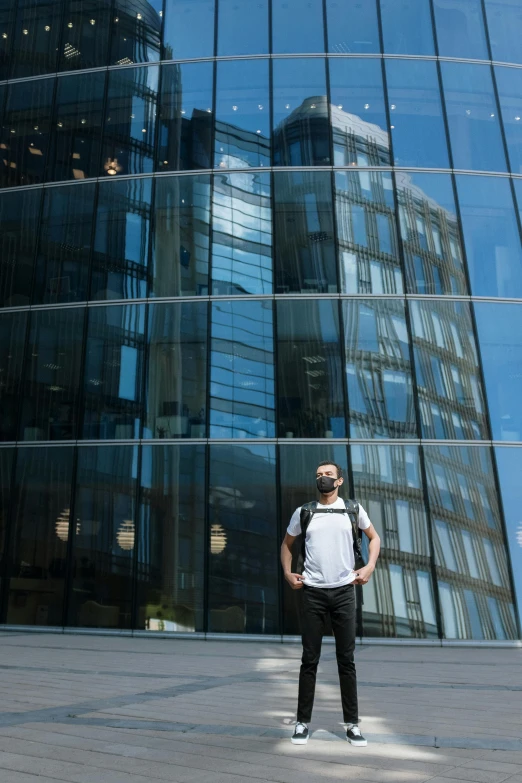 a man standing in front of a tall building, buildings made out of glass, avatar image, commercial photo, f/1.4