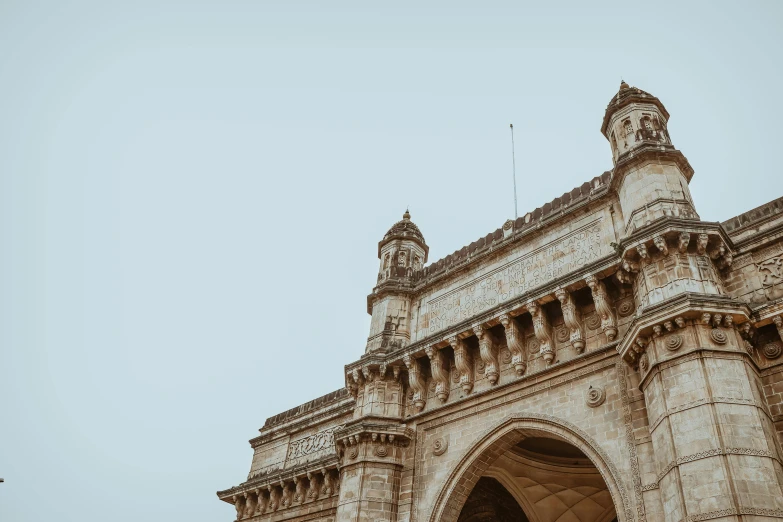 a couple of people that are standing in front of a building, ornate carved architecture, in sci - fi mumbai, unsplash photography, background image