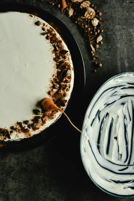 a cake sitting on top of a table next to a bowl of frosting, a still life, inspired by Joris van der Haagen, trending on pexels, vanilla smoothie explosion, mocha swirl color scheme, closeup - view, thumbnail