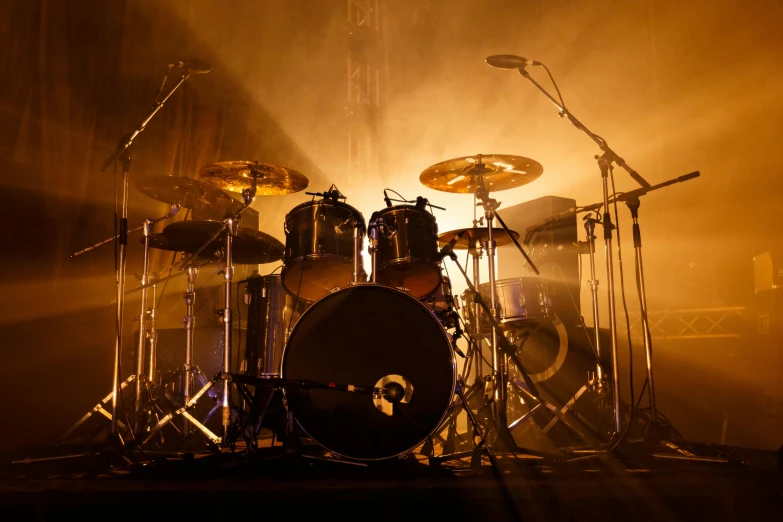 a drum kit sitting on top of a stage, by Jay Hambidge, shutterstock, yellow lighting from right, profile image, sports photo, the band name is roborock