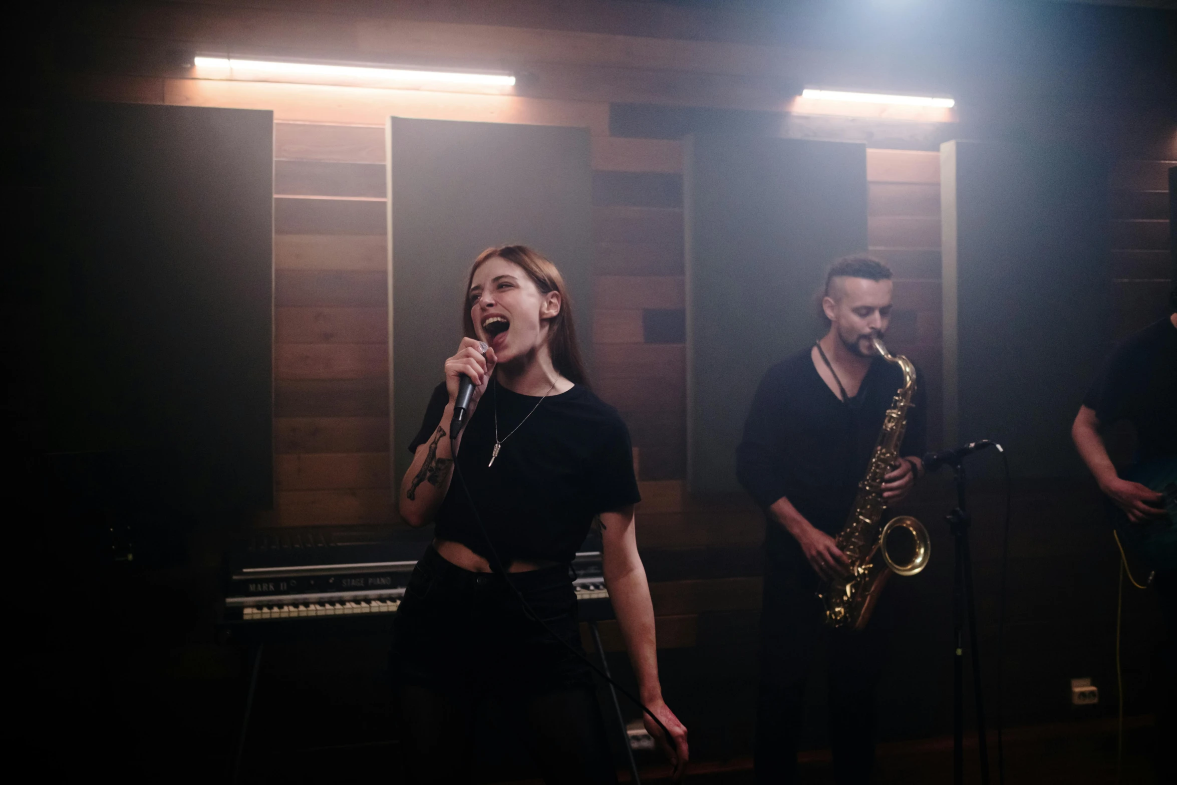 a group of people that are standing in front of a microphone, saxophone, performing a music video, profile image, indoor picture