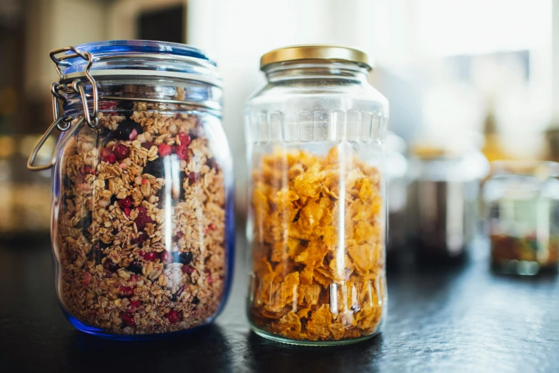 a close up of two jars of food on a table, by Nina Hamnett, pexels, cereal, botanicals, 4l, rectangle