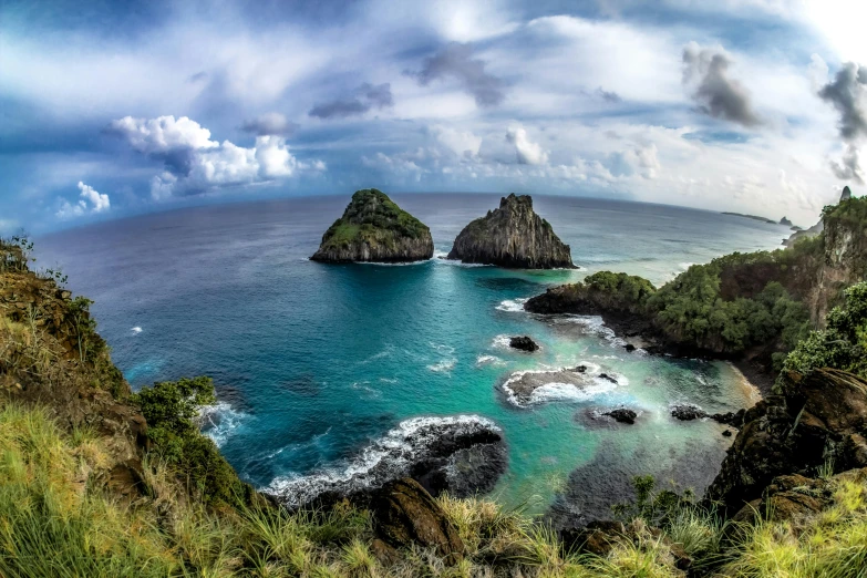 a large body of water sitting on top of a lush green hillside, by Peter Churcher, pexels contest winner, two medium sized islands, rock arcs, mami wata, photo of the middle of the ocean