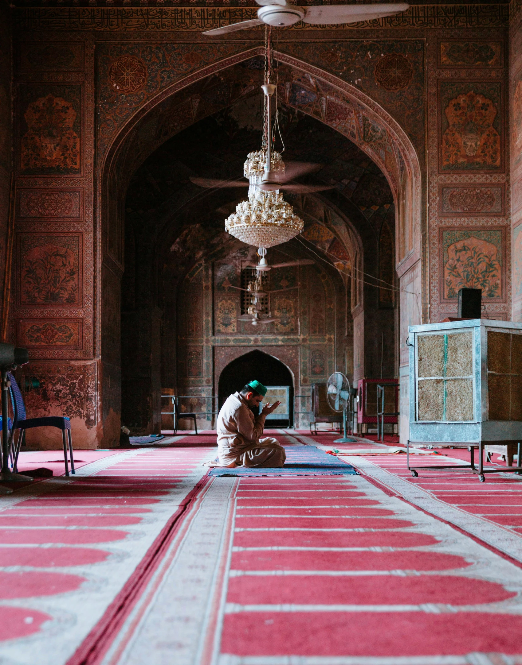 a man sitting on the floor of a mosque, unsplash contest winner, pink marble building, gif, brown, shrine