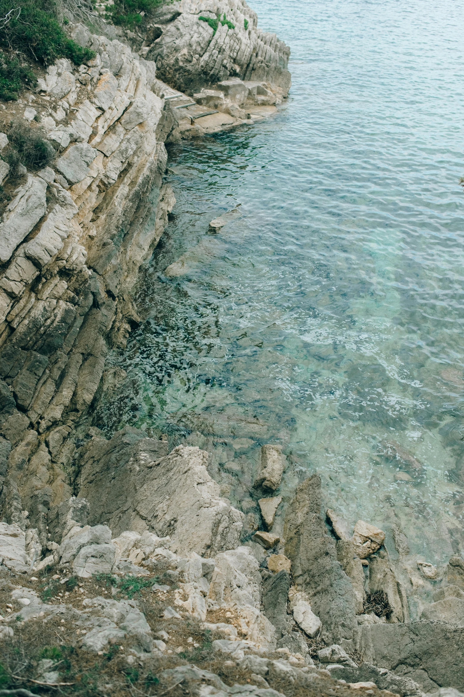 a man standing on top of a rock next to a body of water, turquoise palette, sea floor, manly, cinq terre