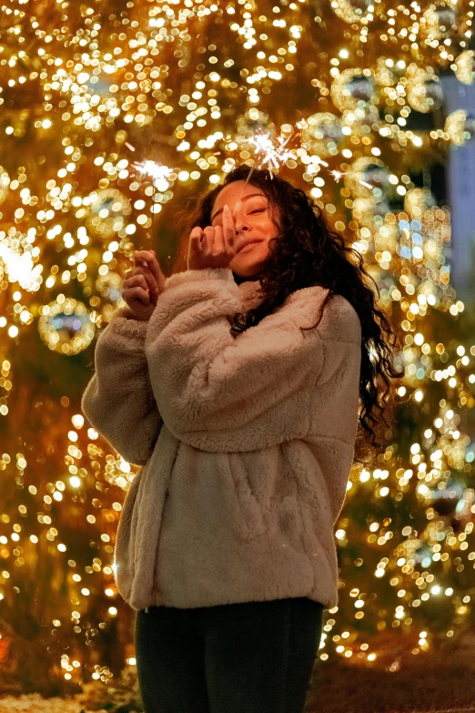 a woman standing in front of a christmas tree, trending on pexels, visual art, fireball lighting her face, sza, wearing a grey fur robe, a young asian woman