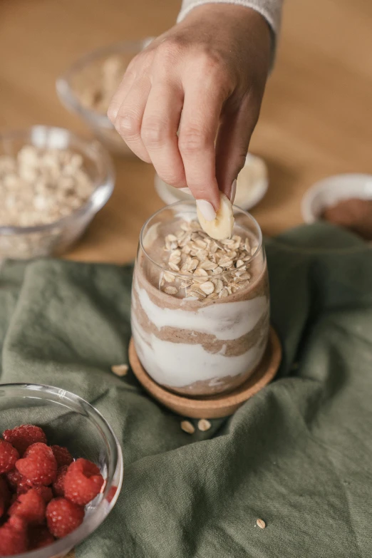 a person scooping some oatmeal into a bowl of raspberries, trending on pexels, renaissance, milkshake, glass jar, fully chocolate, multi - layer