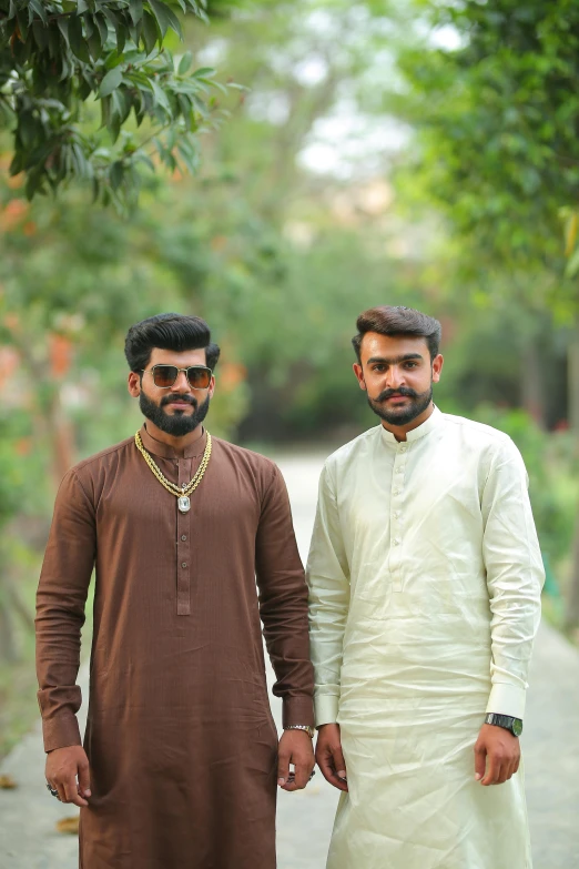 two men standing next to each other on a road, trending on instagram, wearing a kurta, ( ( theatrical ) ), brown, lgbtq