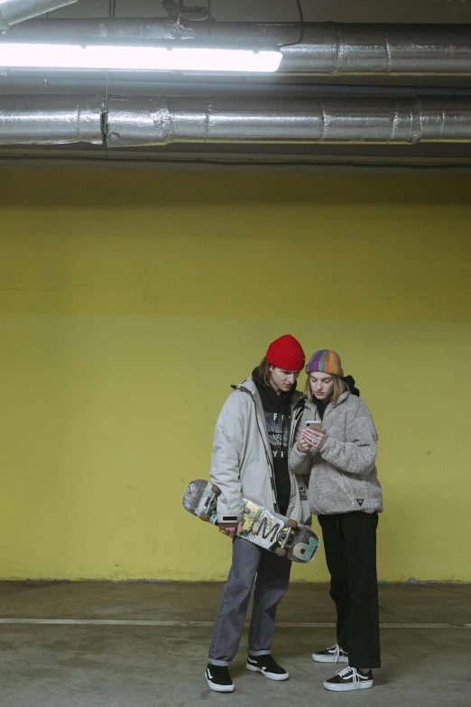 two people standing next to each other in a parking garage, flickr, skateboard, yellow, winter season, ap news photograph