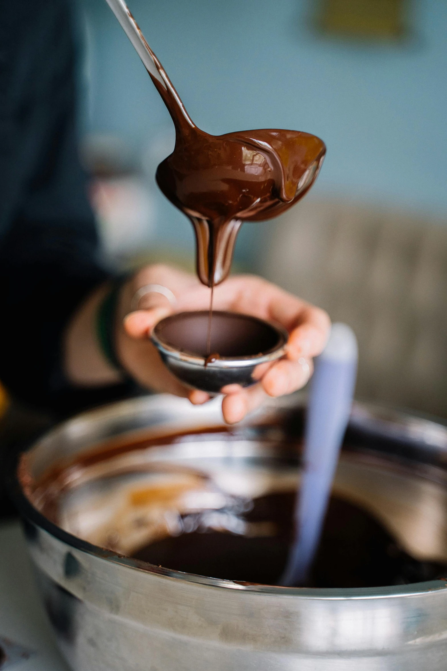 a person pouring chocolate into a bowl with a spoon, dripping wax, highly upvoted, gourmet and crafts, bells