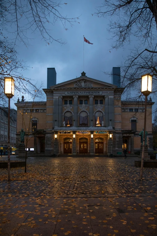 a large building with a lot of lights in front of it, by Jens Søndergaard, theater, calm weather, autumnal, square