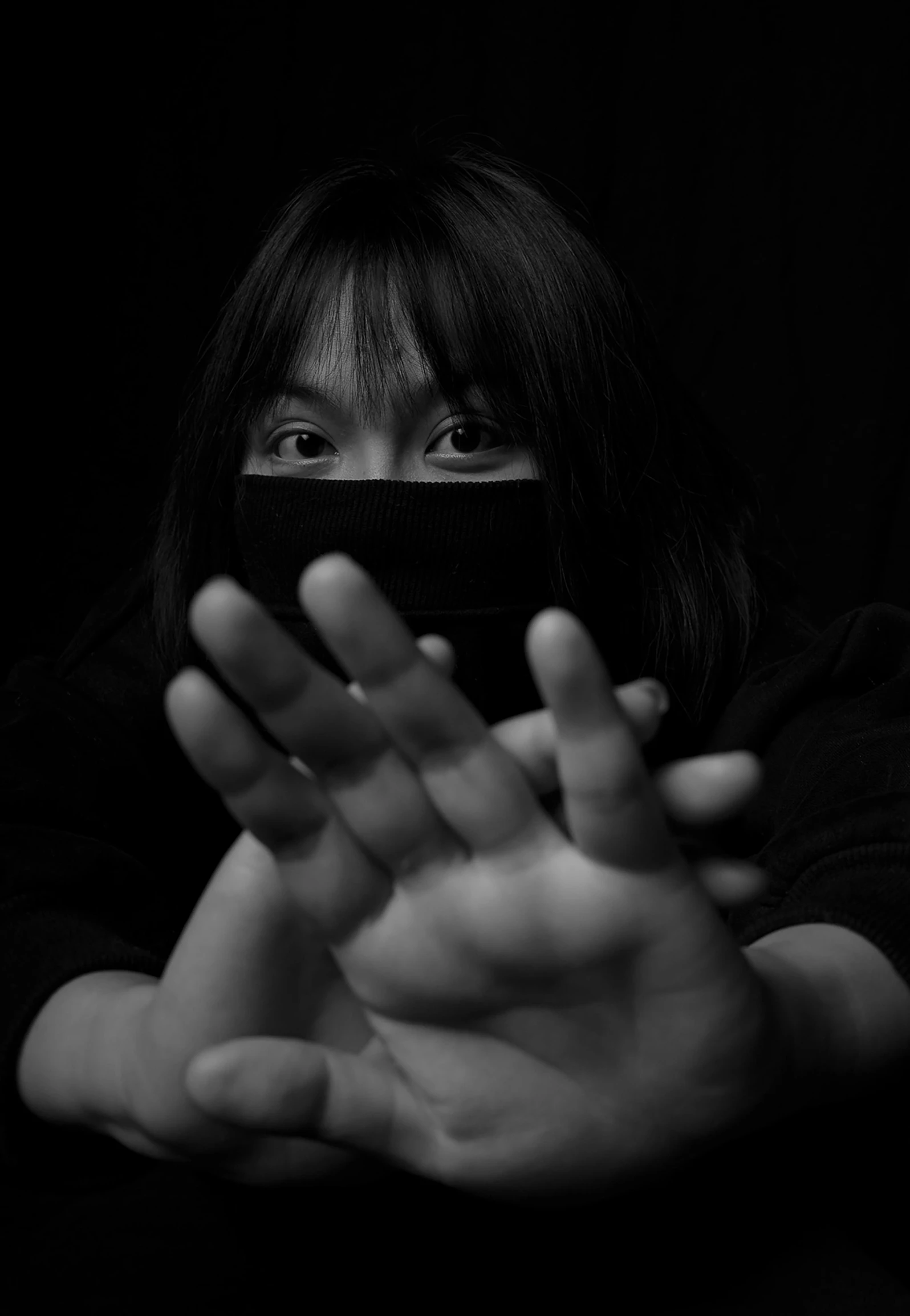 a woman holding a cell phone up to her face, a black and white photo, inspired by Yu Zhiding, pixabay, visual art, white bandages on fists, yume nikki, portrait of a vigilante, asian woman