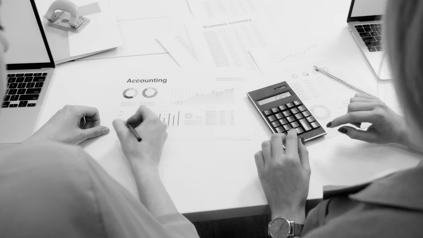 a woman sitting at a table with two laptops and a calculator, a black and white photo, by Daniel Lieske, pexels, process art, corporate business, on white paper, ui and ux, numerical