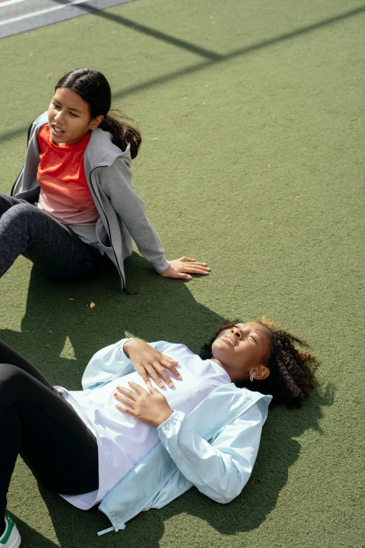 a couple of women laying on top of a tennis court, an album cover, by Nina Hamnett, pexels contest winner, happening, kids, injured, standing sideways, 15081959 21121991 01012000 4k