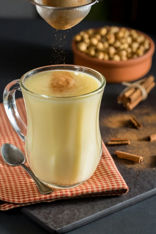 a close up of a cup of food on a table, inspired by Géza Dósa, reddit, renaissance, vanilla smoothie explosion, cinnamon, high quality product image”, square