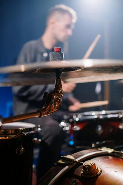 a man sitting in front of a drum set, zoomed in, neck zoomed in, uploaded, high quality photo