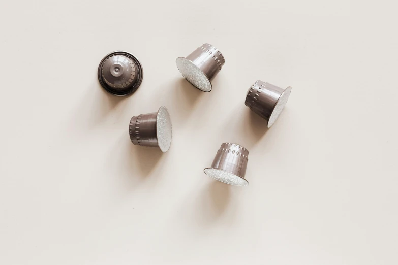 a group of coffee cups sitting on top of a table, grey and silver, healing pods, 5 mm, rosetti