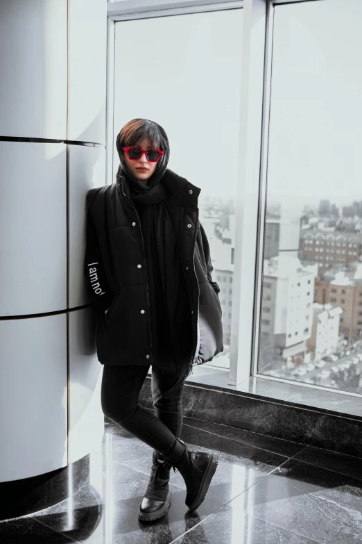 a woman standing in front of a large window, trending on r/streetwear, wearing black coat, cold shades, trending in japan