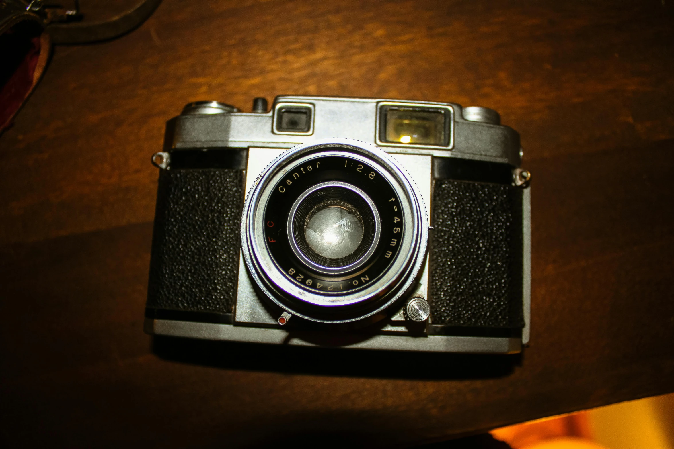 a camera sitting on top of a wooden table, by Mathias Kollros, unsplash, photorealism, fujicolor with flash, 1950’s, icon, a high angle shot