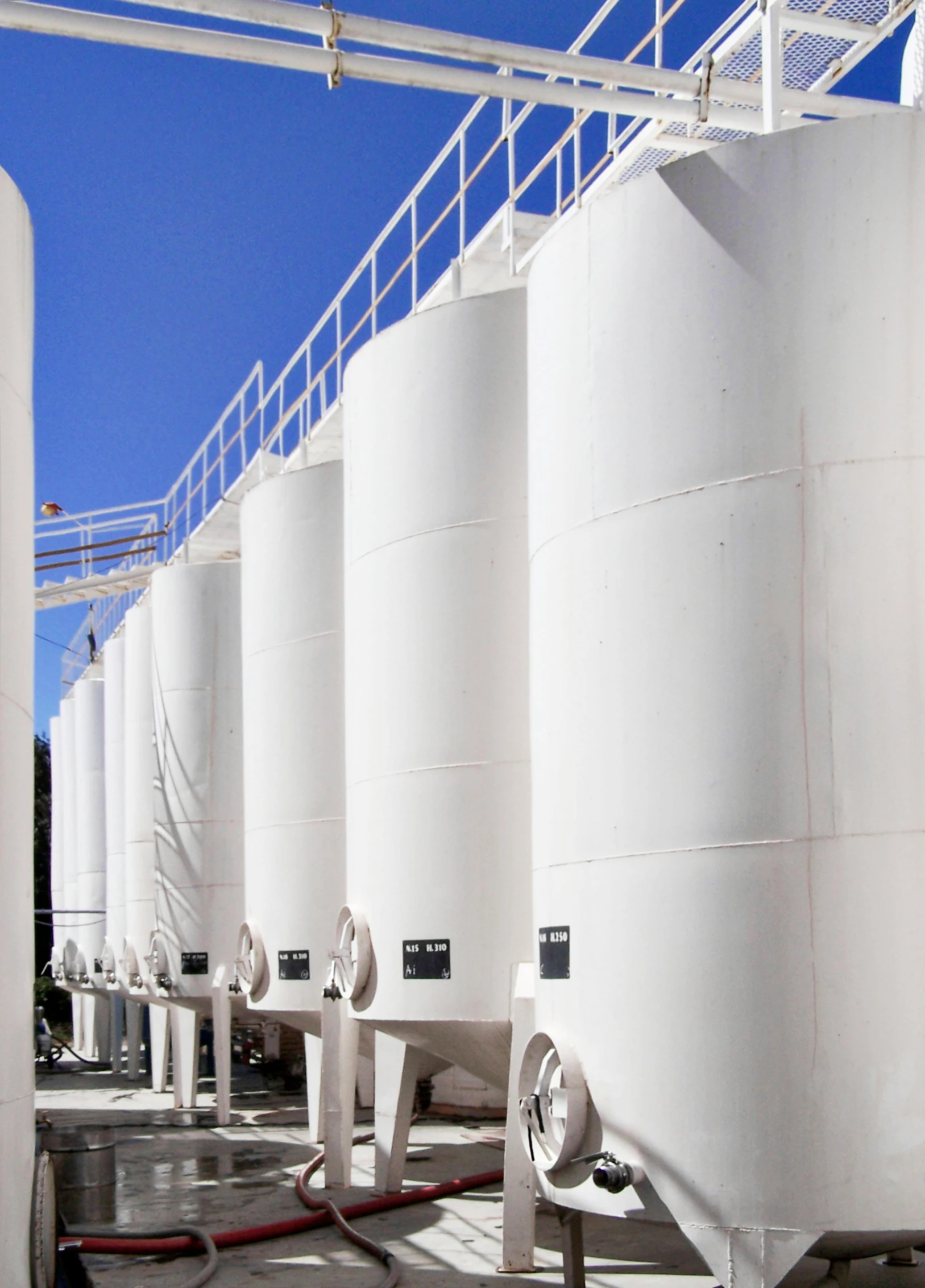 a row of white tanks sitting next to each other, industrial apparent, profile image, blue sky, vessels