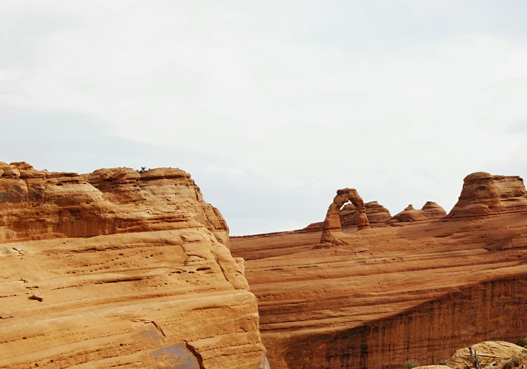 a motorcycle parked on the side of a dirt road, pexels contest winner, les nabis, red sandstone natural sculptures, white sweeping arches, in the style wes anderson, panoramic