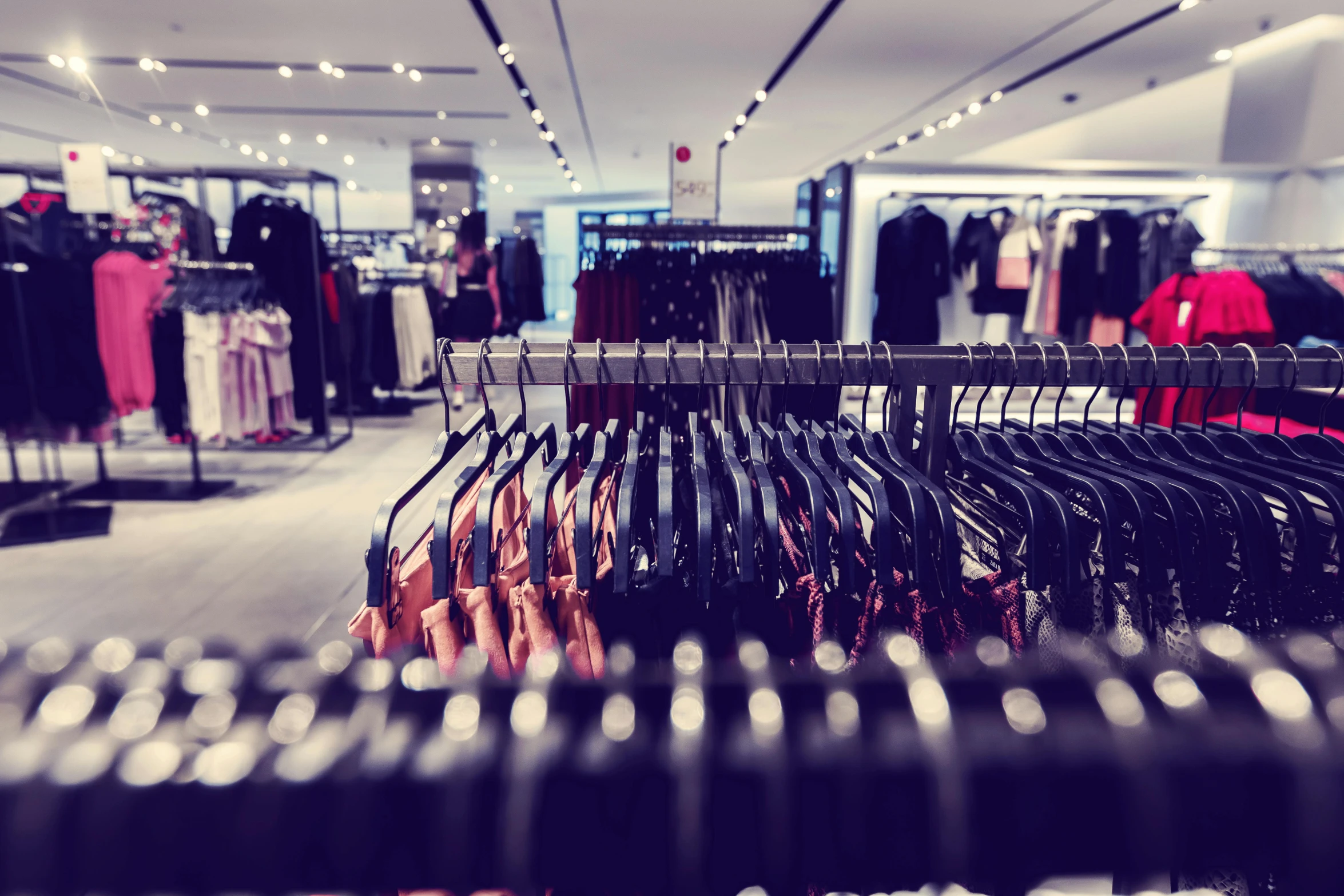 a rack of clothes in a clothing store, by Emma Andijewska, unsplash, in magnificent shopping mall, 💋 💄 👠 👗, purple and black clothes, thumbnail