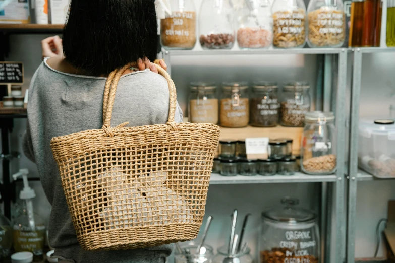 a woman holding a wicker bag in a store, pexels contest winner, jar on a shelf, clean and simple design, food particles, curated collections