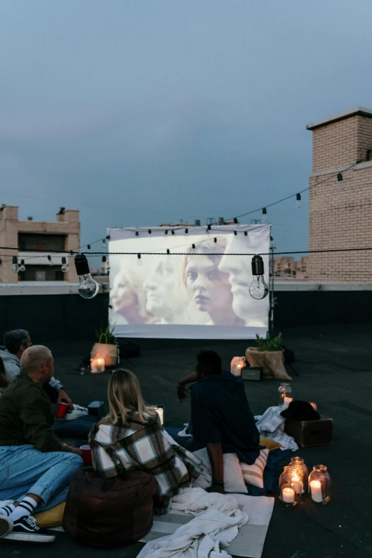 a group of people sitting on top of a roof watching a movie, slate, square