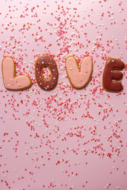 the word love spelled with doughnuts and sprinkles on a pink background, by Julia Pishtar, panel, 15081959 21121991 01012000 4k