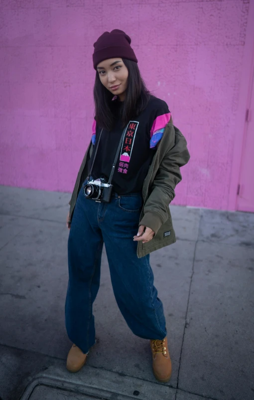 a woman standing on a sidewalk in front of a pink wall, inspired by Wang E, unsplash, she is wearing streetwear, shot with a camera flash, cropped shirt with jacket, 15081959 21121991 01012000 4k