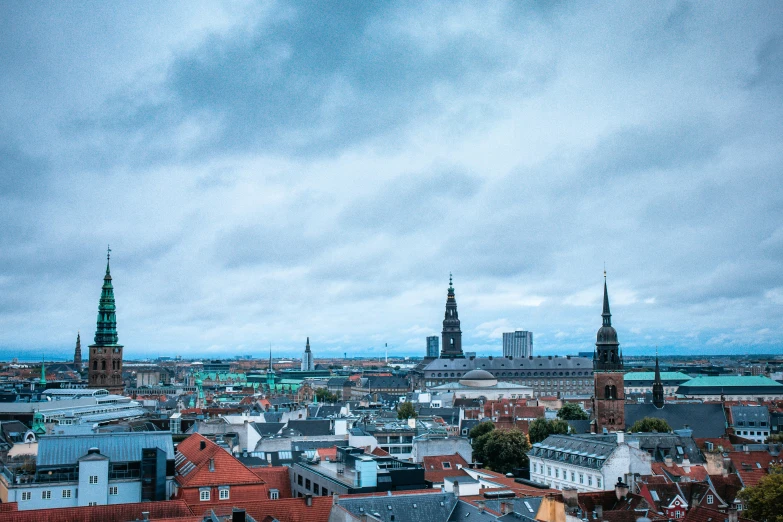 a view of a city from the top of a building, by Christen Dalsgaard, pexels contest winner, baroque, spire, bjarke ingels, blue, slight overcast weather