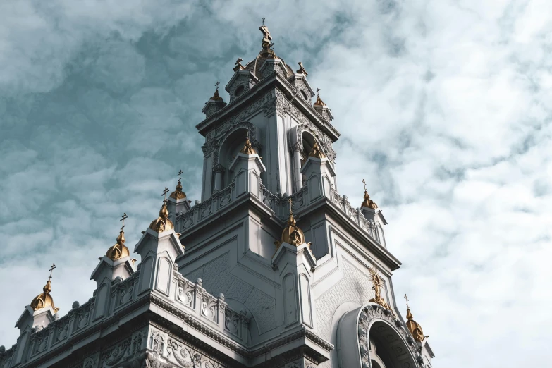 a very tall building with a clock on it's side, an album cover, unsplash contest winner, baroque, church, grey, silver with gold trim, indian temple