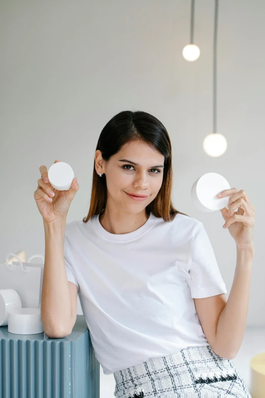 a woman in a white shirt and a black and white skirt, trending on pexels, light and space, her face in discs, soft pads, thin healing glowing devices, product introduction photo
