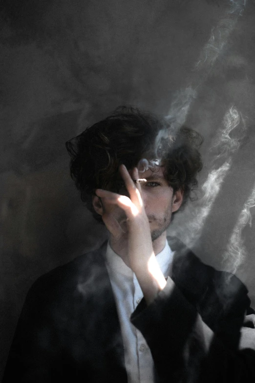 a man in a suit smoking a cigarette, an album cover, inspired by Romaine Brooks, pexels contest winner, magical realism, finn wolfhard, ignant, whirling smoke, profile pic