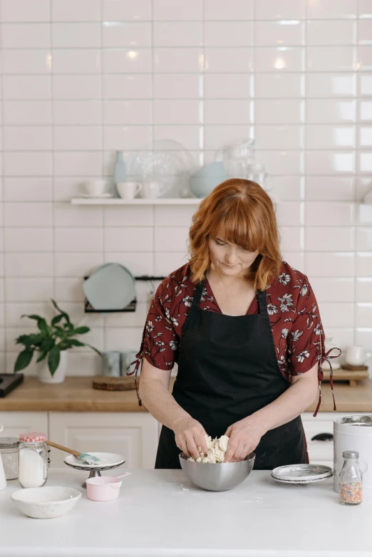 a woman standing in a kitchen preparing food, by Liza Donnelly, ginger hair with freckles, puff sleeves, food stylist, profile image