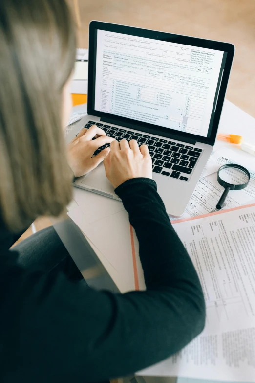 a woman sitting at a table working on a laptop, by Carey Morris, trending on unsplash, highly detailed rounded forms, excel running on the computer, classic fantasy, 15081959 21121991 01012000 4k