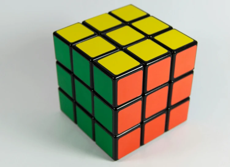 a rubik cube sitting on top of a table, inspired by Ernő Rubik, unsplash, cubo-futurism, yellows and reddish black, vert coherent, square, 3 pm