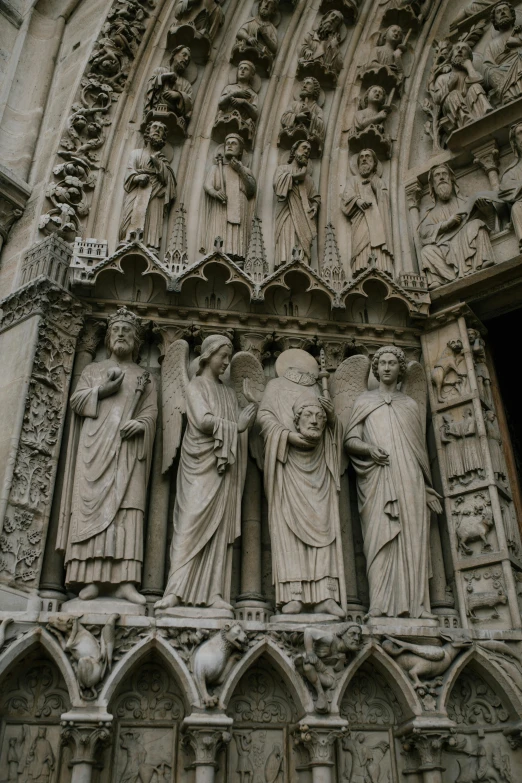 a group of statues on the side of a building, cathedrals, doorways, up-close, full height sculpture