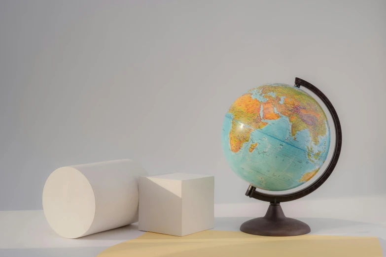 a globe sitting on top of a table next to cubes, a 3D render, by Ruth Simpson, trending on unsplash, plain background, material pack, product introduction photo