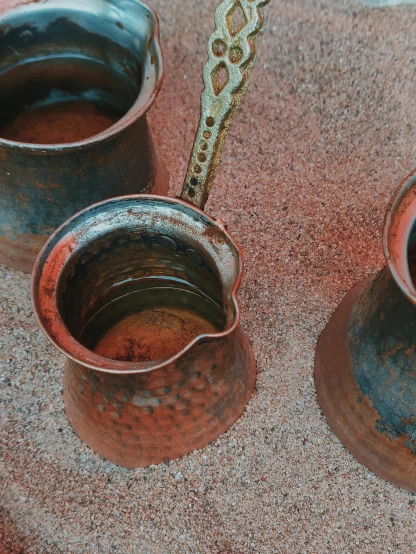 a couple of cups sitting on top of a table, rusty shapes, thumbnail, pouring, middle eastern details