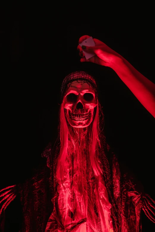 a man dressed as a demon in a dark room, a statue, by Matt Cavotta, pexels, vanitas, covered in red slime, skeleton pirate, glowing pink face, female death holding a cocktail