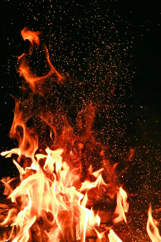 a close up of a fire on a black background, pexels, particles and dust in the air, promo image, instagram photo, tall