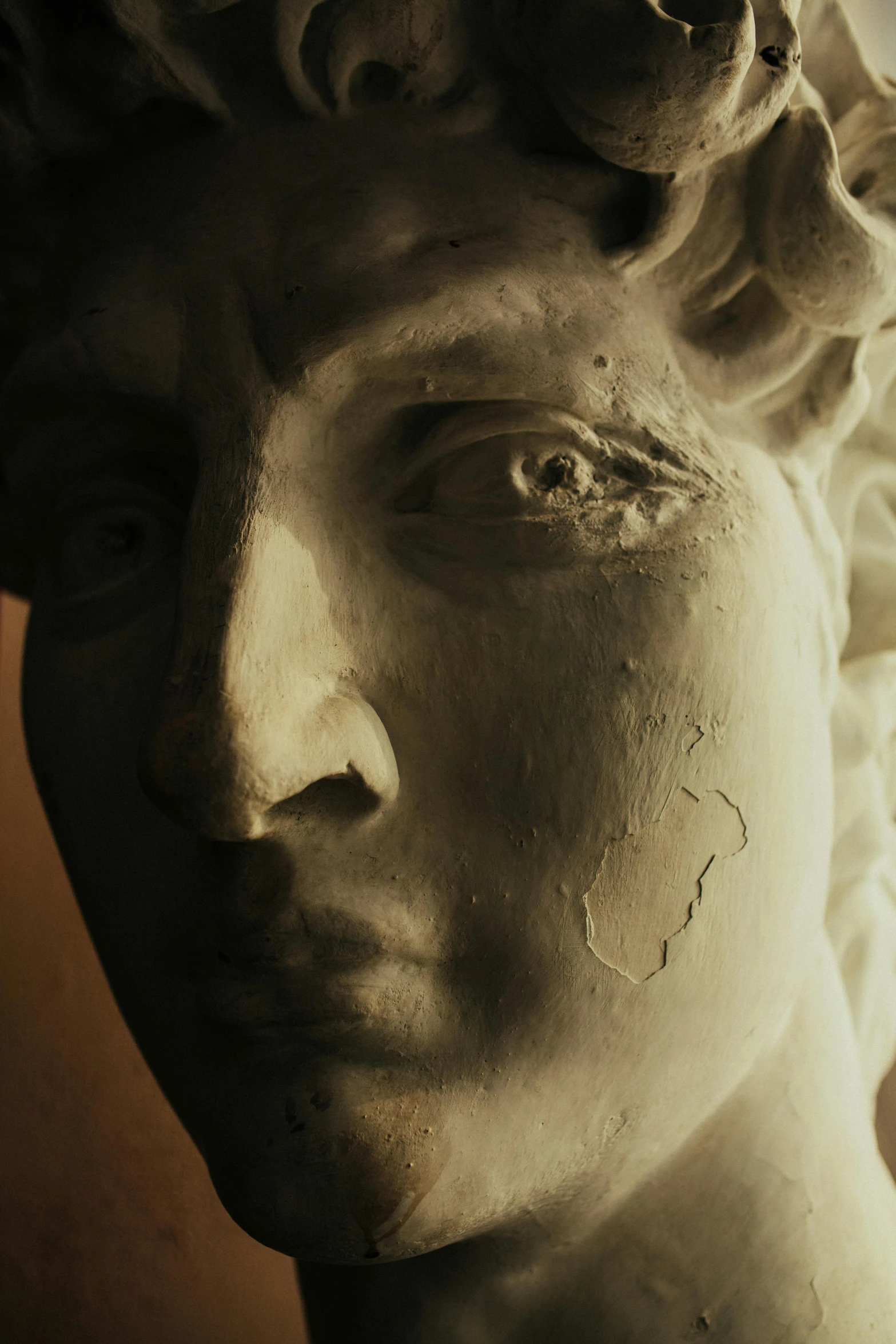 a close up of a statue of a man's face, a marble sculpture, trending on pexels, mannerism, face in-frame, old masters light composition, her face framed with curls, subject made of cracked clay