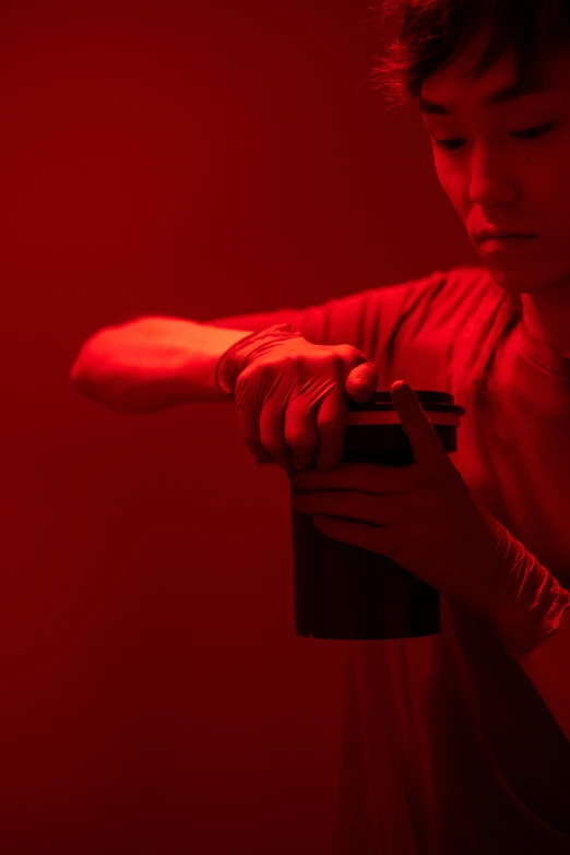 a man holding a video game controller in his hand, an album cover, inspired by Nan Goldin, unsplash, conceptual art, red tank-top, jingna zhang, powder, ignant
