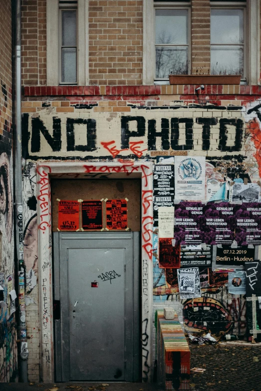 a building with graffiti on the side of it, a photo, by Niko Henrichon, trending on unsplash, graffiti, no speech bubbles, low quality instant camera photo, old photo scattered, storefront