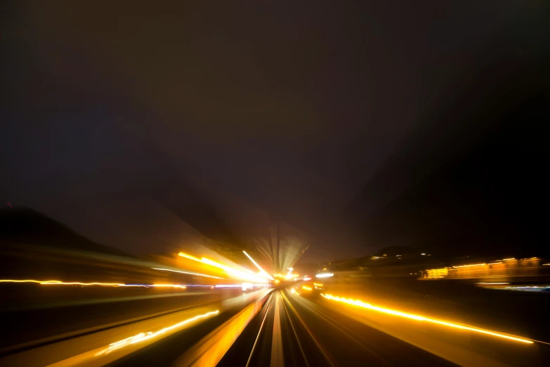 a blurry image of a city at night, by Thomas Häfner, unsplash, driving fast, yellow flash, freeway, photographed for reuters