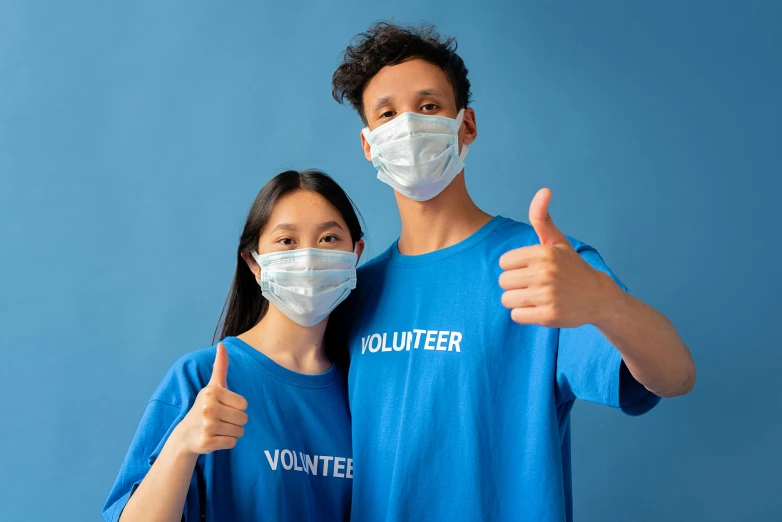 a man and woman wearing face masks giving a thumbs up, pexels contest winner, blue themed, tshirt, healthcare worker, decoration