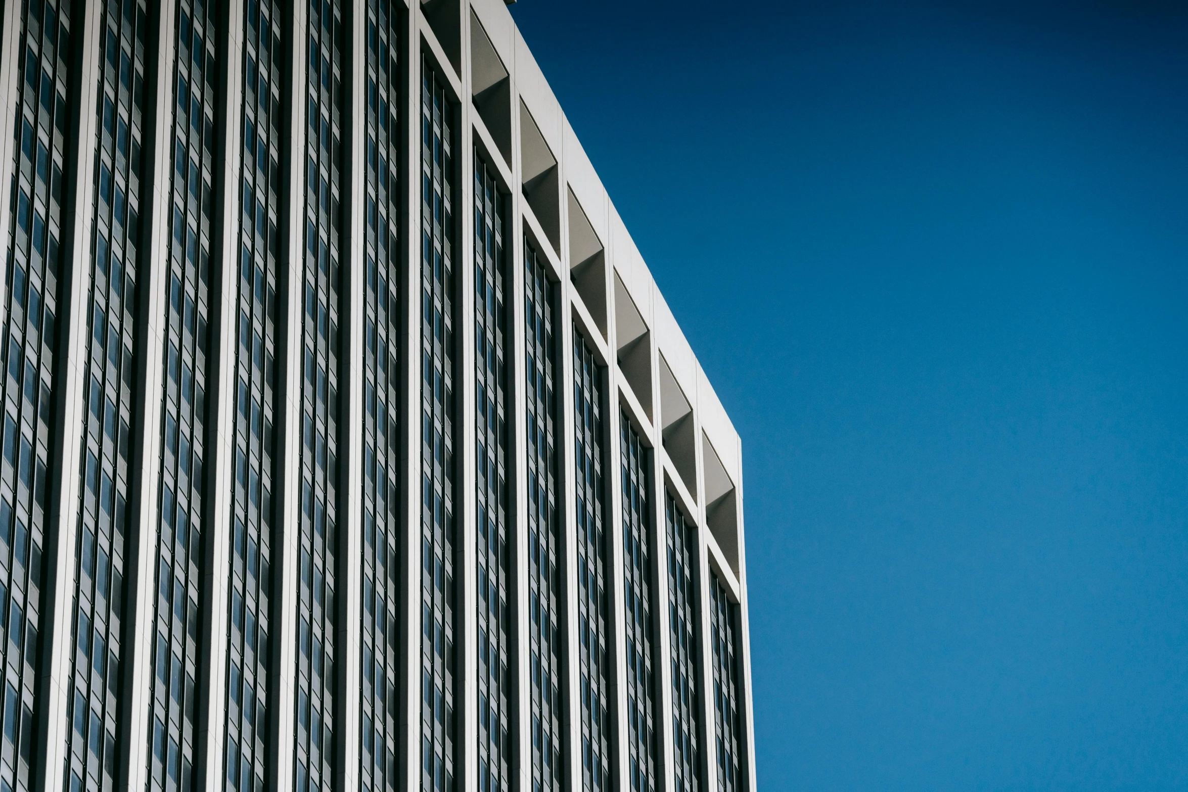 a tall building with a blue sky in the background, a photo, unsplash, brutalism, square lines, epic. 1 0 0 mm, high quality image, 1 2 9 7