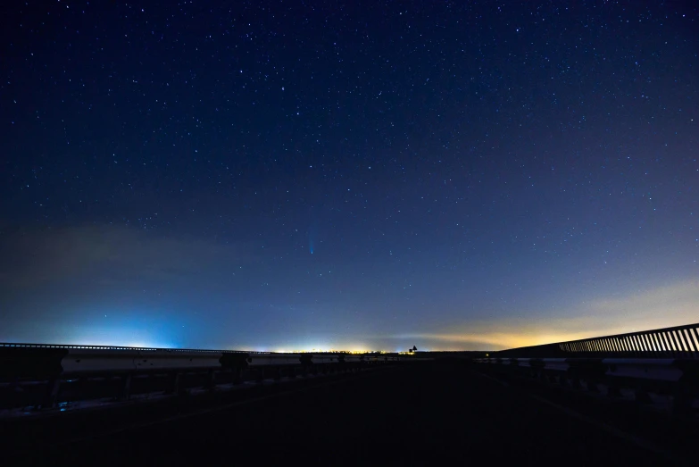 a train traveling over a bridge at night, by Eglon van der Neer, light and space, panorama view of the sky, big island, blue: 0.5, moonlit parking lot